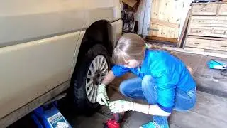 Анастасия учится менять колесо у автомобиля, а папа меняет колодки