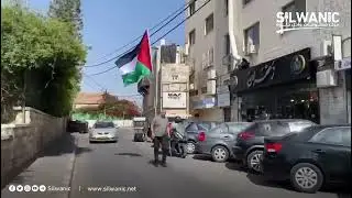 الناشط المقدسي محمد ابو الحمص يسير في شوارع القدس رافع العلم الفلسطيني على ظهره