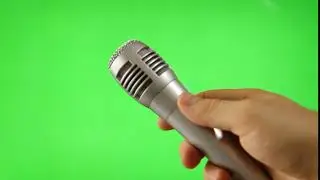 Holding Up A Microphone Isolated On Green Screen