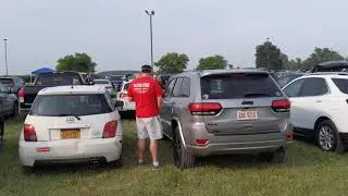 Man peeing between cars