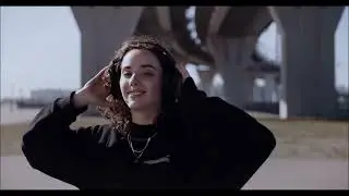 Красивая девушка в наушниках танцует