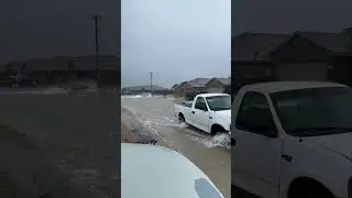 Person on Floaer Floating Down a Flooded Street After West Texas Rain