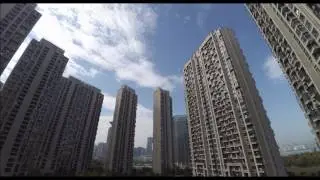 Timelapse: Tall buildings, floating clouds