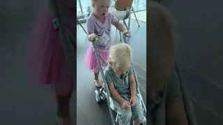 Старшая сестра Наоми катает Маленько Дэвида на детской коляске