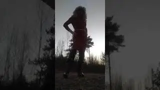 Crossdresser transvestite. In a  red dress a nd high- heeled boots.