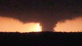 Lightning illuminates a huge nighttime tornado over Barnsdall, Oklahoma
