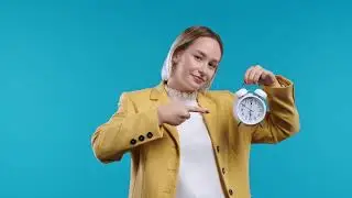 Happy student woman with alarm clock on blue background  Early morning, correct day routine, living