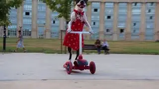 Dog Wearing Red Dress Rides Scooter