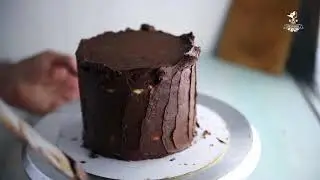 We level the cake with ganache under the mastic