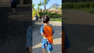 Free footage | two children walking to the field with mountain and some plantation area