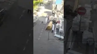 Узбек с листом гипрока борется с ветром.