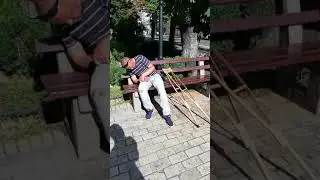 Пьяный на костылях спит на скамейке.