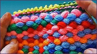 Knitting a rug from homemade pompon yarn.