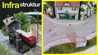 Locomotive depot, streets, ROCKS, corner store, and bus stop on H0 layout 