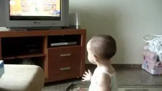 Letícia: em pé no tio Marcelo assistindo Mister Maker