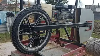 A homemade band sawmill with motorcycle wheels, first run after winter.