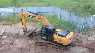 yellow excavator lifting wooden blocks - footage