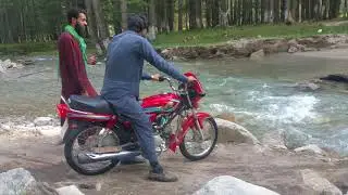 Kumrat valley crossing water on bike