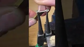 Cleaning twisted silver wire chain links.