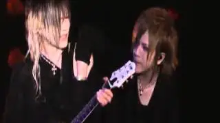Ruki puts his hand in Uruha's Shirt