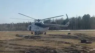Вертолёт берёт груз на подвеске.