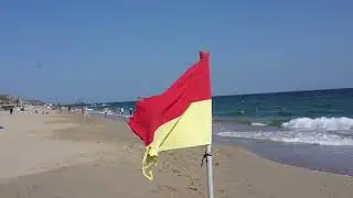 Пляжные желто - красные флаги информируют о безопасной зоне под наблюдением спасателей.
