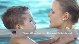 Boy kissing mother while bathing in the sea