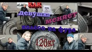 A girl changes a tire on a truck