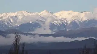 Timelapse Clouds Drifting Across Snowy Mountains