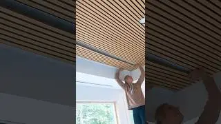 Installing acoustic slat panels on a ceiling. 