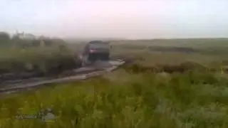 Грузовой военный автомобиль КАМАЗ застрял в грязи в дождь