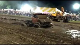unimog 406 drives through a sandpit with mud.