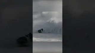 A giant wave hits a surfer and his lifeguard