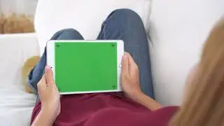 Young Asian Woman Using Black Tablet Device With Green Screen.