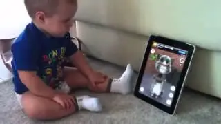 Funny baby talks with cat on iPad