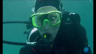 Female scuba diver investigates the sea floor after a scuba 