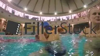 Joyful Kid with mom bathing in the pool