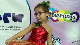 Николь выступает на сцене с танцем.