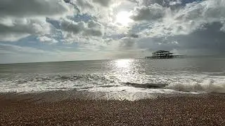 Waves crashing on Brighton Beach with Palace Pier in the background.