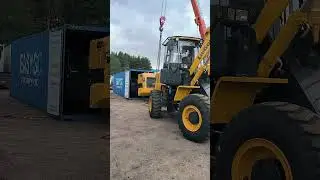 кран помогает достать погрузчик из контейнера 