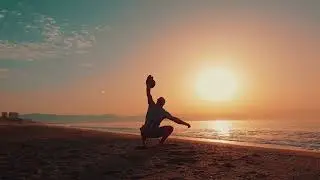 ФУТАЖ. Мужик на берегу моря тренируется с гирей (A man on the beach is training with a kettlebell)