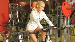 Beautiful Blonde Woman Riding a Bike at Gym Centre #stockfootage