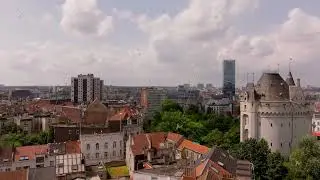 Camera pans over the Brussels skyline, revealing the historic Halle Gate amidst a sea of traditional