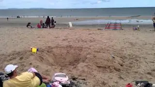 On the beach casually jumping down a hole
