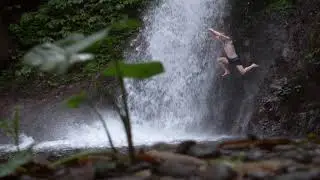 Человек прыгает с уступа в водопад