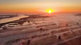 Zonsopkomst bij molens Kinderdijk en De Schans in de nevel - drone 4K