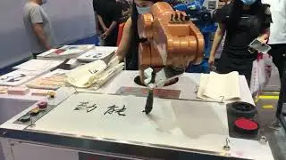 Коллаборативный робот пишет кистью.