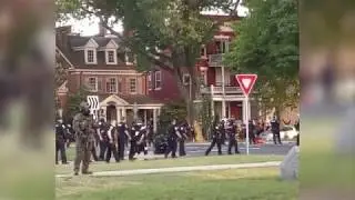 Police appear to be spitting spitting on or near detained protester.