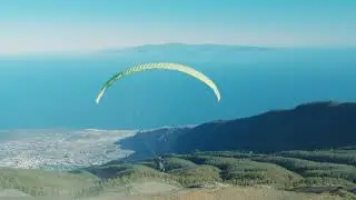 paragliding with pilot adjusting wing controls cha D8RLJ5P