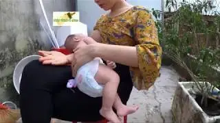 2 months old baby Thinh is breastfeeding outside backyard with having a sun tan